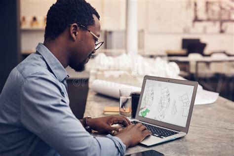 Working His Magic A Handsome Young Male Architect Working On A Laptop