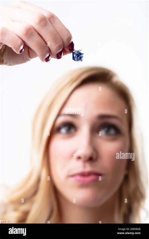 Blurry Blonde Woman Holding A Tiny Gift In Focus Expressing Disappointment The Present Is