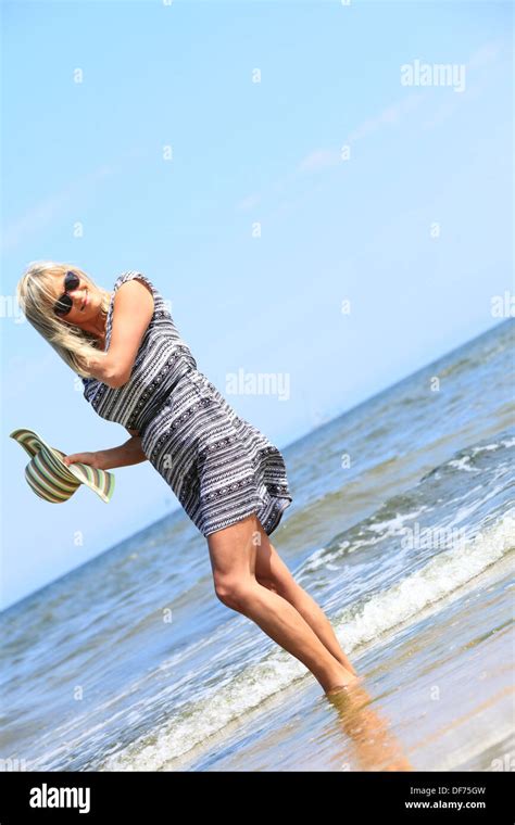 Full Length Mature Woman With Hat On Beach Enjoying Summer Holiday Stock Photo Alamy