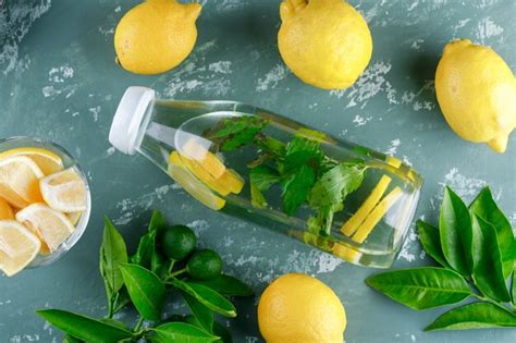 Лимонная вода с мятой, листья в бутылке на поверхности штукатурки ...