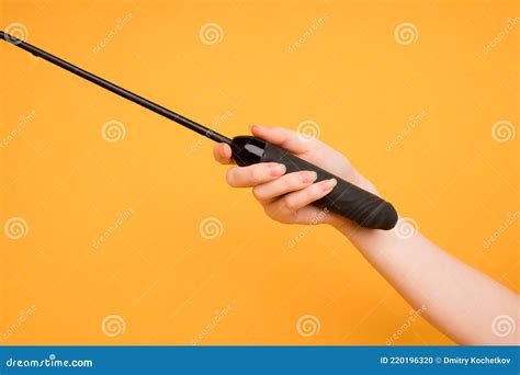 Fouet En Cuir Noir Dans Une Main De Femme Sur Un Fond Orange Sex Toys Espace Pour Texte Utile