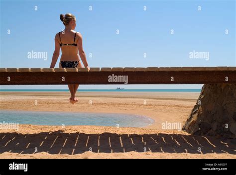 Female Teenager Sitting On Bridge In Bikini Beach Stock Photo Alamy