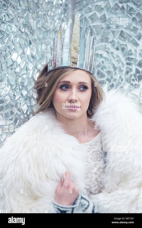 Frozen Princess Blonde Woman In Glass Crown In A White Fur Coat Posing As A Snow Queen In Rose