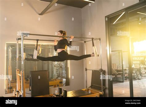 Woman Performs An Advanced Flexibility Exercise On A Pilates Reformer