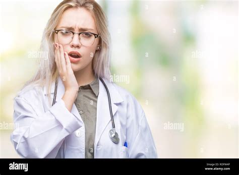 Junge blonde Arzt Frau über isolierte Hintergrund berühren den Mund mit der Hand mit