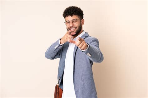 Hombre De Negocios Joven Marroqu Aislado En La Pared Beige Apuntando