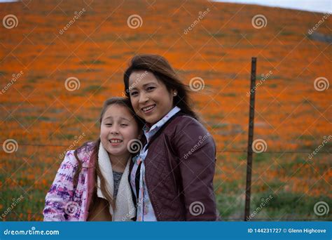 Latina Mother And Daughter In Front Of Desert California Poppy Field Orange Bokeh Stock Image