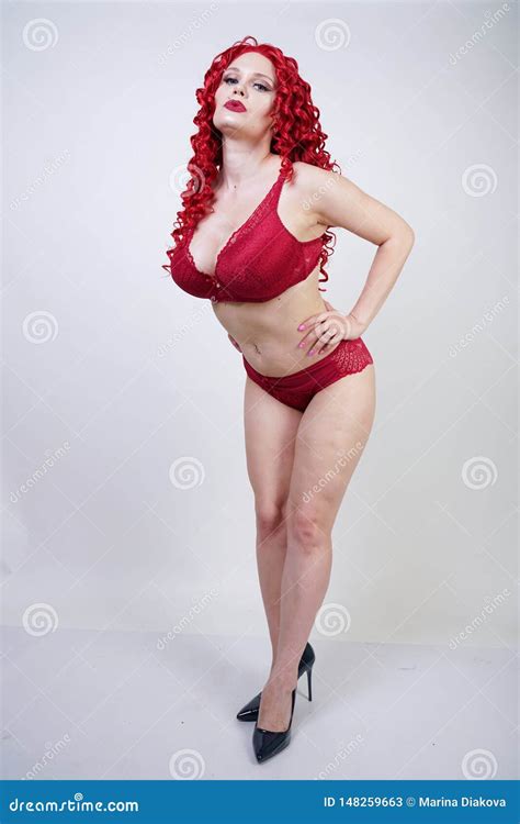 Hot Curvy Girl With Red Curly Hair Wearing Lace Lingerie And High Heels In The Studio Stock