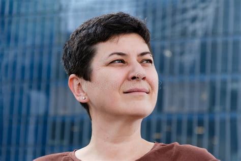Confident Brunette Woman With Short Hair Looking Into Distance Against