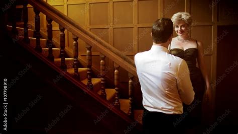 Attractive Blonde Woman Wearing A Classic Vintage Fifties Dress Flirts With A Handsome Man In A