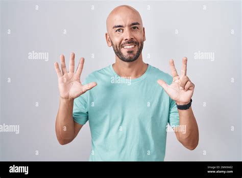 Middle Age Bald Man Standing Over White Background Showing And Pointing Up With Fingers Number