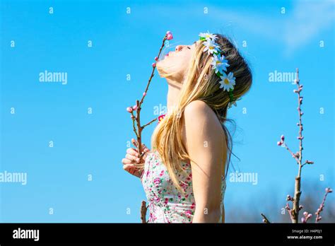 Blonde Woman With Flowery Dress Kissing A New Spring Flower Stock Photo Alamy