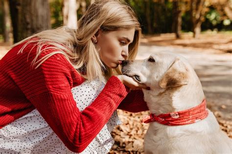 Jolie Fille Blonde Embrassant Son Beau Labradour Jeune Femme V Tue De Rouge Avec Son Chien Dans