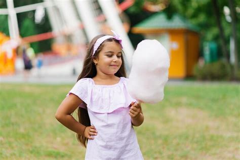 Premium Photo A Cute Darkskinned Girl In A Pink Dress Holds Cotton