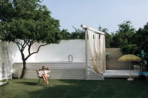 Tanned Girl In A White Shirt On A Naked Body A Woman In A White Shirt Wearing Sunglasses Sits