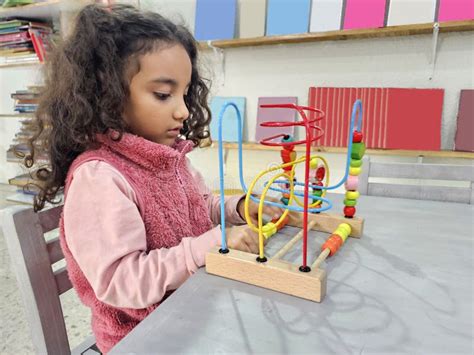 Year Old Latina Girl With Curly Hair Plays An Educational Game Like A Wooden Maze For