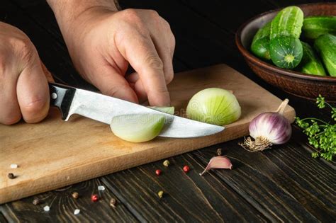 Slicing Onions On A Cutting Board By The Hands Of A Cook For Preparing