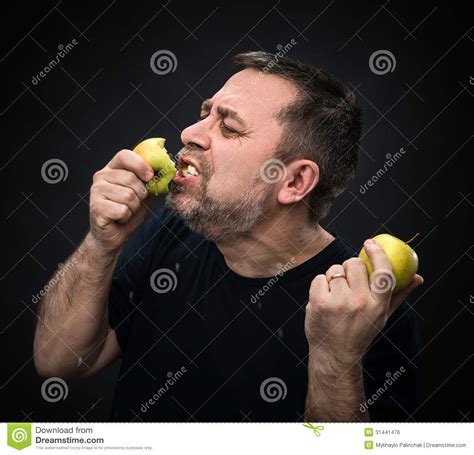 Hombre Con Un Apetito Que Come Una Manzana Verde Foto De Archivo