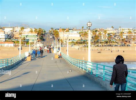 People Enjoy The Sunset At Scenic Beach And Pier At Manhattan Beach