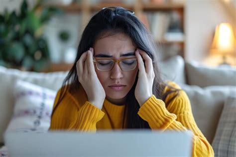 Mulher latina exausta tirando óculos e esfregando a ponte do nariz fazendo uma pausa no trabalho