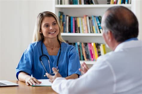 Infirmière Blonde En Train De Rire En Train De Parler Avec Un Médecin Photo stock Image du