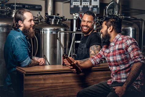 Tres Hombres Elegantes Que Beben La Cerveza Del Arte En El Microbrewery