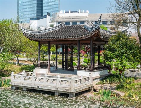 Traditional Chinese Pavilion Over Pond In Urban Park Stock Photo