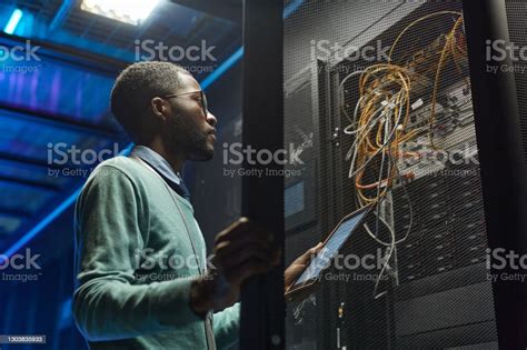 African American Network Engineer Setting Up Server Stock Photo