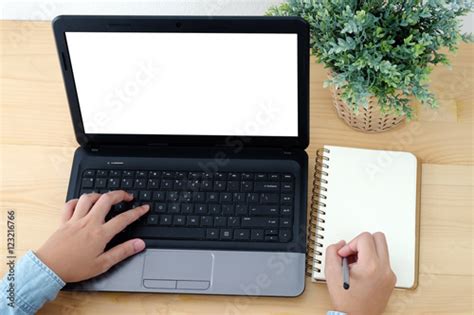 Hand Typing Laptop With Blank Screen And Blank Note Paper Buy This