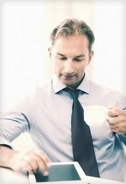 Premium Photo Smiling Businessman With Tablet Pc Drinking Coffee In