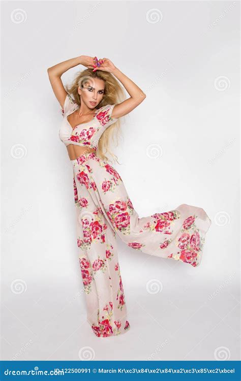 Beautiful Sexy Elegant Woman With Blonde Hair Poses In The Studio In Elegant Clothes With