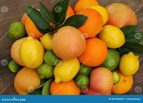 Different Citrus Fruits And Leaves On Wooden Table Closeup Stock Image