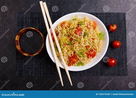 A Serving Of Appetizing Chinese Noodles With Tomatoes And Greens Next