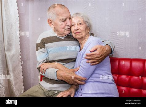Happy Affectionate Mature Old Man And Woman Embracing Looking At Camera