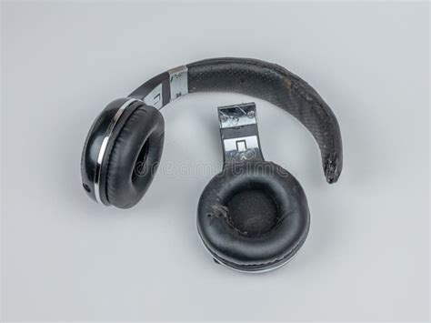 Old Broken Headphones Close Up On A Light Wooden Table The Concept Of