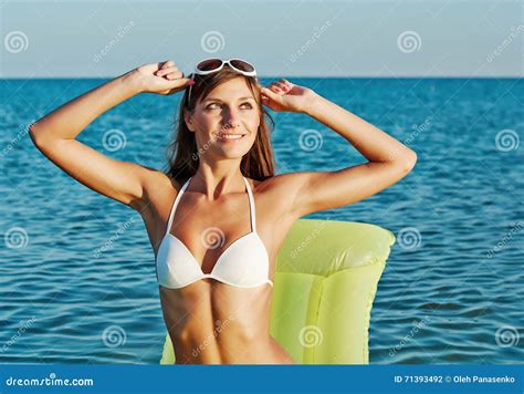 Mooie Gelukkige Vrouw In Witte Bikini Met Gele Opblaasbare Matras Op Het Strand Stock Foto