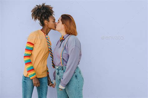 Happy Multiracial Lesbian Couple Kissing And Holding Hands Stock Photo By Gabistock