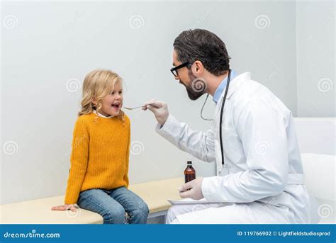 Young Male Pediatrist Giving Mixture To Smiling Stock Photo Image Of