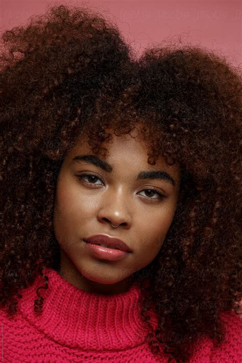 "Portrait Of A Young African American Afro Woman In Pink Studio" by