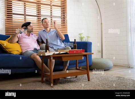LGBTQ Gay Couple Doing Activities Together At Home And Socializing Together Happily Stock Photo