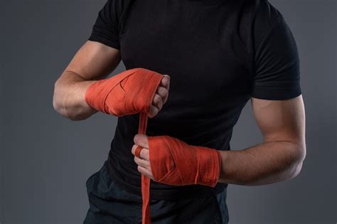 Premium Photo Man Wrapping Hands With Red Tape Preparing For Boxing