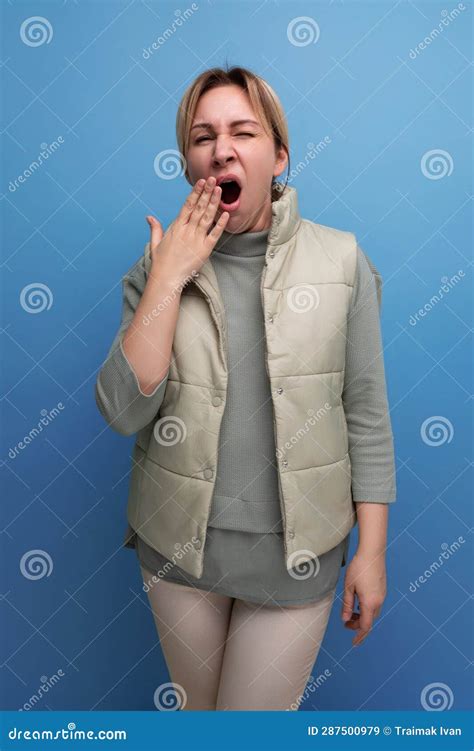 Tired Blonde 30 Year Old Woman In Casual Clothes Yawns Covering Her Mouth Stock Image Image Of