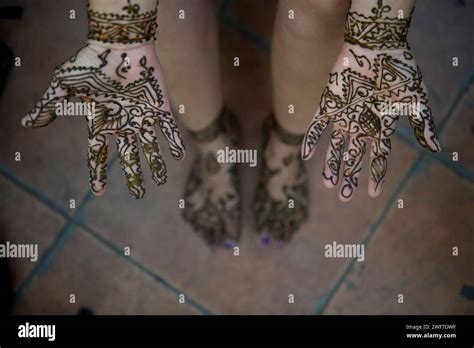 A woman lets her henna tattoo dry on her hands and feet Stock Photo - Alamy