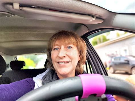 Middle Aged Woman In A Car Taking Selfie While Enjoying A Drive Female Mature Driver Posing