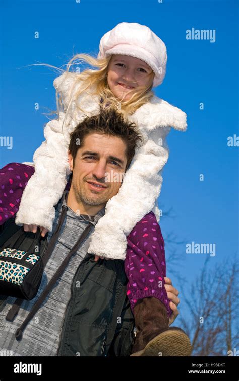 Father Carrying His 7 Year Old Daughter On His Shoulders Stock Photo