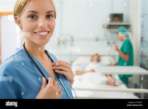 Blonde Nurse Smiling While Touching A Stethoscope Stock Photo Alamy
