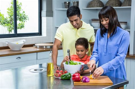 Familia Feliz Preparando Ensalada En La Cocina Foto Premium