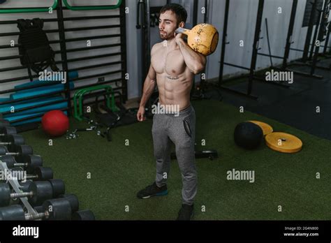 Athletic Male With Naked Torso Doing Exercises With Heavy Kettlebell