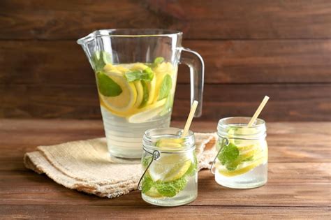 Premium Photo Jars And Jug Of Fresh Lemonade On Wooden Background