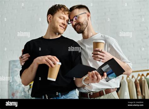Two Men Part Of A Gay Couple Stand United While Crafting Stylish Clothing In Their Designer